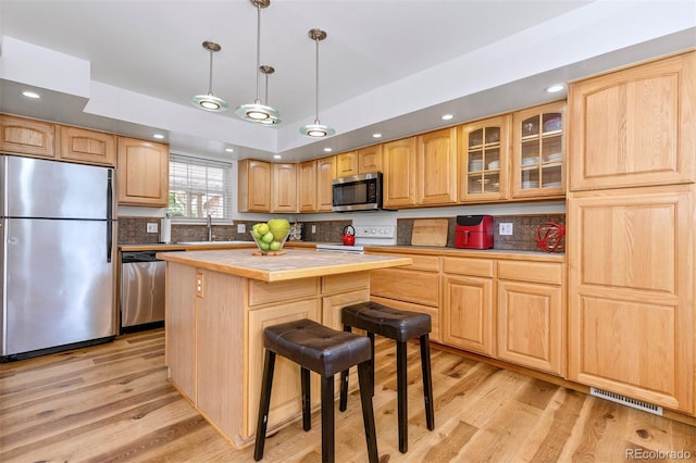 2650 S Vaughn Way Unit B, Aurora, CO 80014 - kitchen featuring appliances with stainless steel finishes, a sink, light wood-style floors, a center island, and recessed lighting