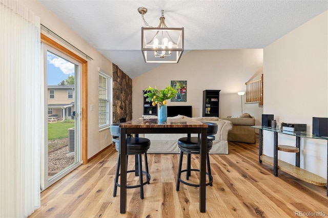 2650 S Vaughn Way Unit B, Aurora, CO 80014 - dining room featuring lofted ceiling, light wood-style flooring, and a chandelier