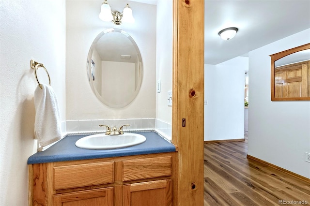 2650 S Vaughn Way Unit B, Aurora, CO 80014 - bathroom featuring vanity, wood finished floors, and baseboards