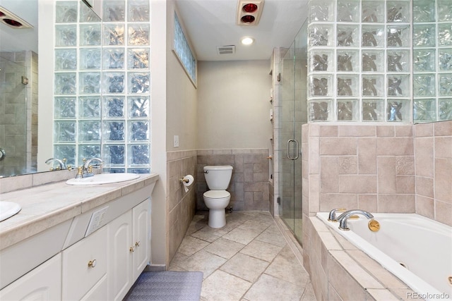 2650 S Vaughn Way Unit B, Aurora, CO 80014 - bathroom featuring tile walls, a garden tub, vanity, a shower stall, and toilet