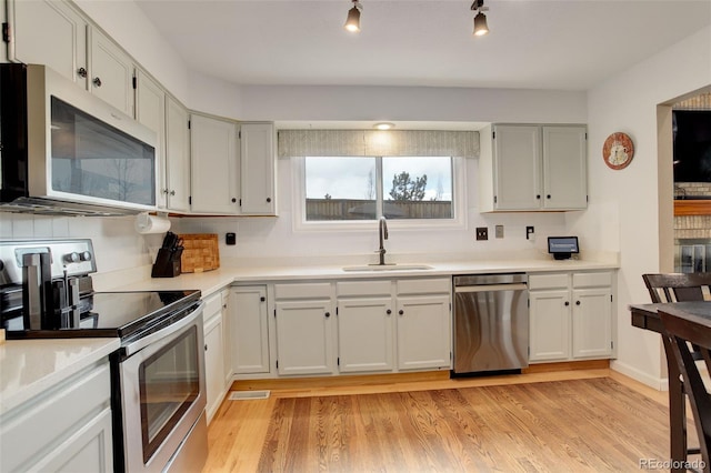 10059 Granite Hill Dr, Parker, CO 80134 - kitchen with light countertops, light wood-type flooring, stainless steel appliances, and a sink