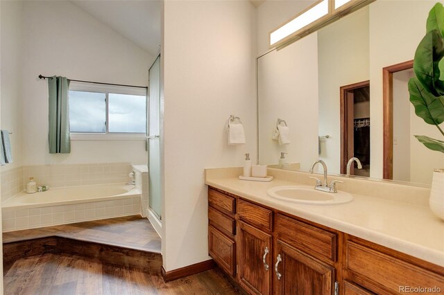 10059 Granite Hill Dr, Parker, CO 80134 - full bath with wood finished floors, a bath, lofted ceiling, a shower stall, and vanity