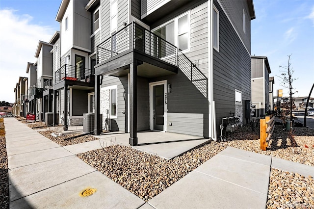 view of side of home with a patio and central AC unit