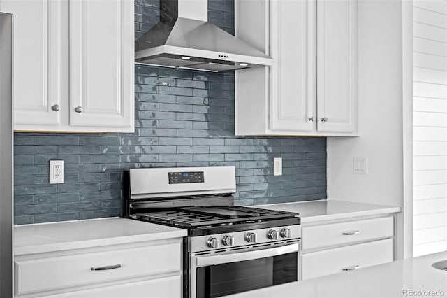 kitchen featuring gas stove, wall chimney range hood, white cabinets, and backsplash