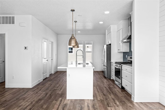 kitchen with sink, appliances with stainless steel finishes, hanging light fixtures, an island with sink, and white cabinets