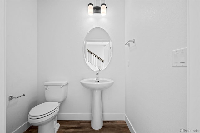 bathroom featuring wood-type flooring and toilet