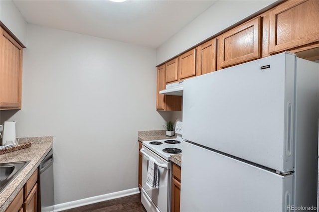 kitchen featuring dark hardwood / wood-style flooring, white appliances, and sink