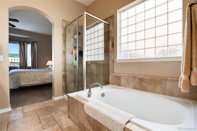 bathroom featuring ceiling fan and plus walk in shower