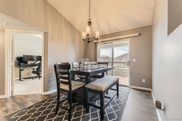 dining space featuring lofted ceiling, dark hardwood / wood-style floors, and an inviting chandelier