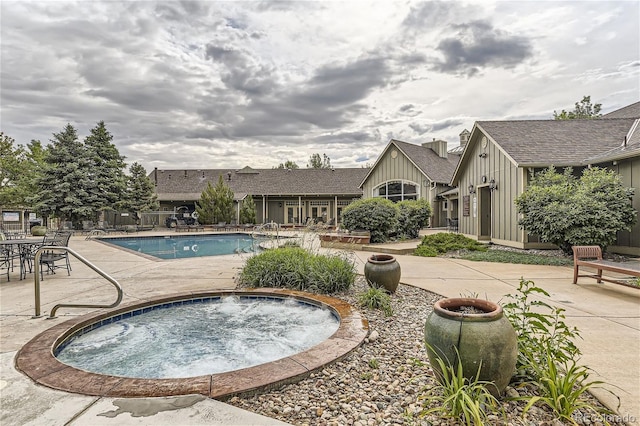 view of swimming pool featuring a patio area and a hot tub