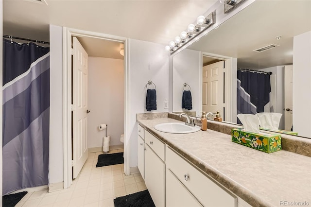 bathroom featuring toilet, tile patterned floors, and vanity