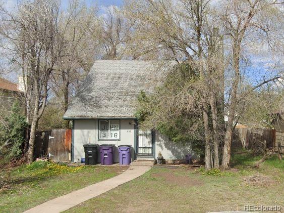 view of front of property featuring fence, a front lawn, and stucco siding