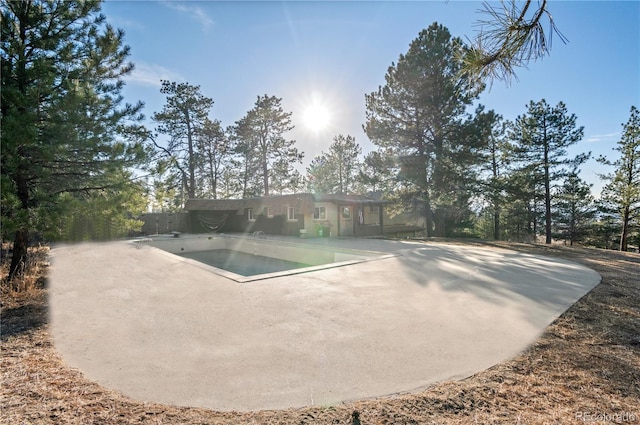 back of property featuring a patio and an empty pool