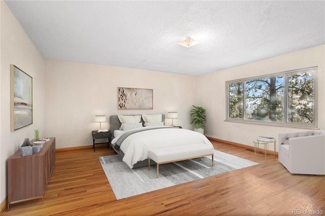 bedroom featuring light hardwood / wood-style floors and a textured ceiling