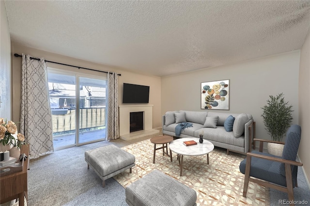 living room with carpet floors, a fireplace with raised hearth, and a textured ceiling