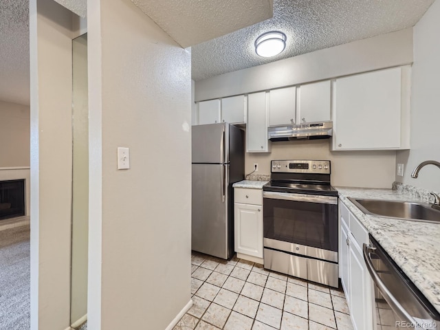 kitchen featuring under cabinet range hood, appliances with stainless steel finishes, white cabinets, and light countertops