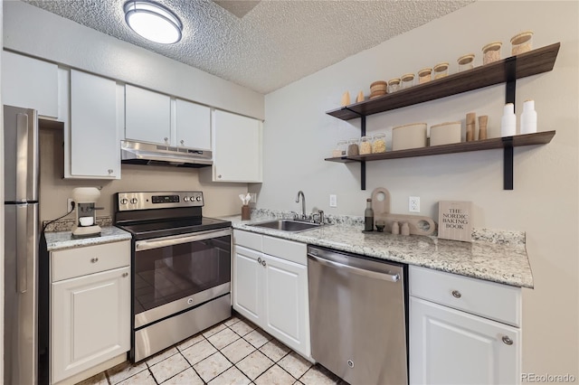 kitchen featuring stainless steel appliances, white cabinets, a sink, a textured ceiling, and under cabinet range hood