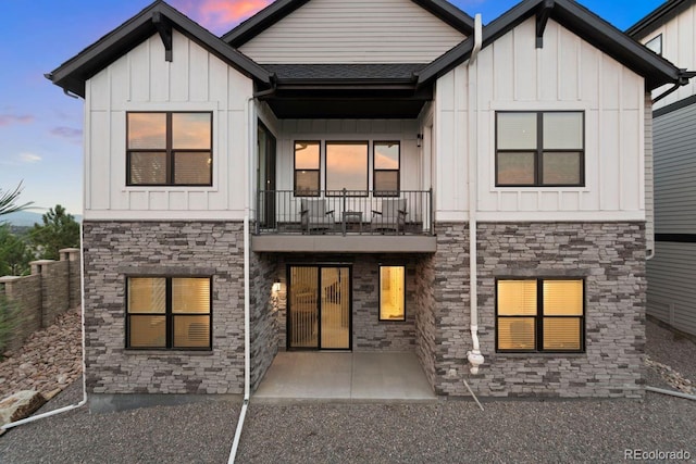7022 Homeplace St, Castle Rock, CO 80108 - rear view of house with a balcony, board and batten siding, and stone siding