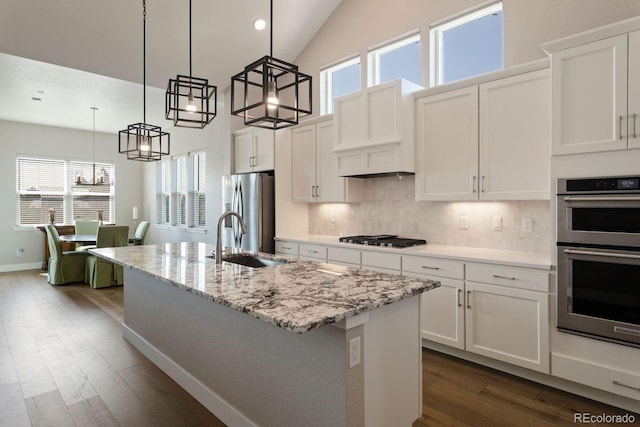 7022 Homeplace St, Castle Rock, CO 80108 - kitchen featuring stainless steel appliances, a sink, dark wood-style flooring, a center island with sink, and white cabinetry