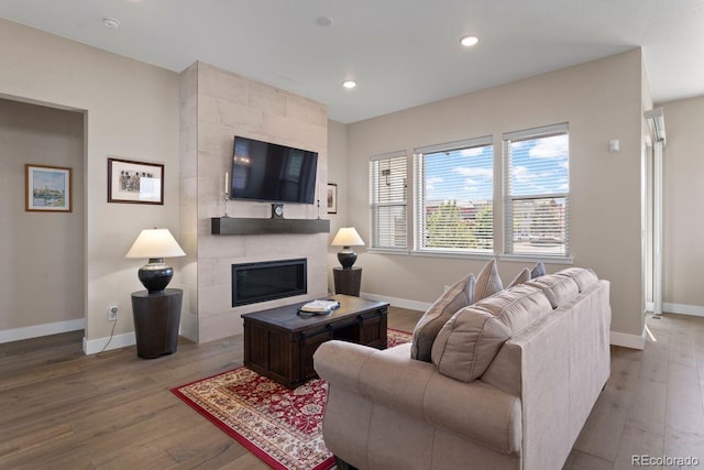 7022 Homeplace St, Castle Rock, CO 80108 - living area featuring baseboards, wood finished floors, a tiled fireplace, and recessed lighting
