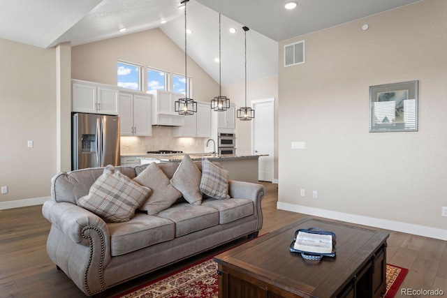 7022 Homeplace St, Castle Rock, CO 80108 - living area with baseboards, dark wood-style flooring, high vaulted ceiling, and recessed lighting