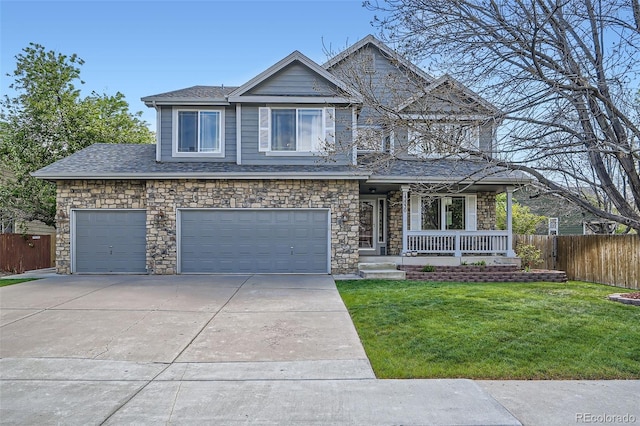 craftsman-style home featuring fence, a front lawn, stone siding, covered porch, and driveway