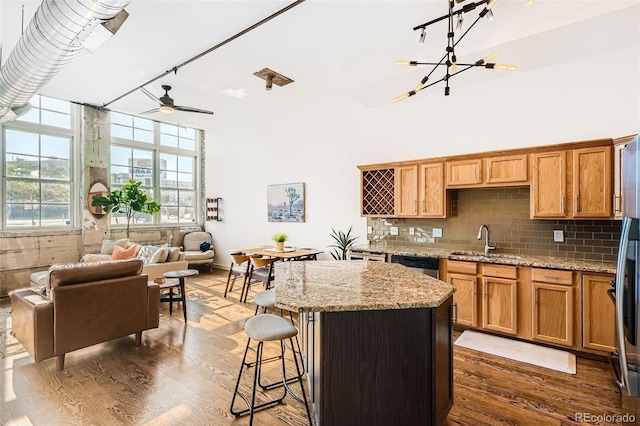 kitchen featuring a center island, light stone countertops, sink, and dark hardwood / wood-style floors