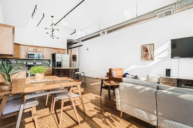 dining space with a notable chandelier, a high ceiling, and hardwood / wood-style floors