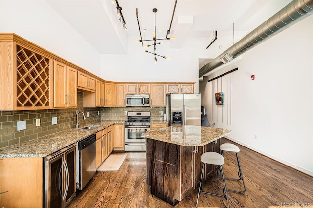 kitchen with a kitchen island, light stone countertops, stainless steel appliances, and dark hardwood / wood-style floors