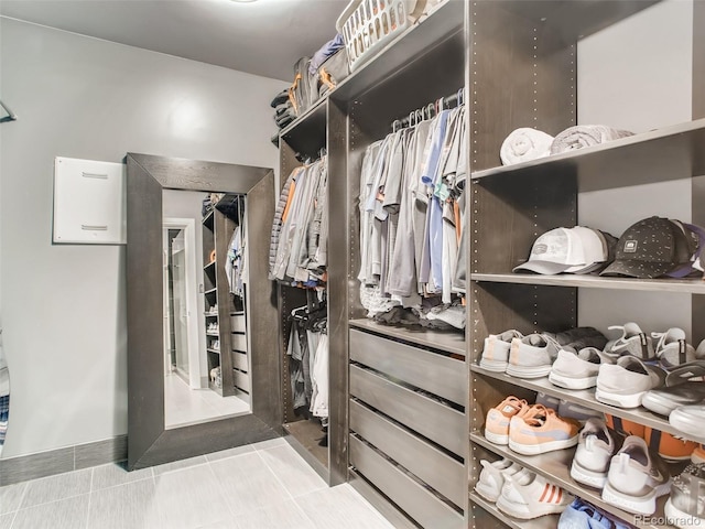 walk in closet with light tile patterned floors