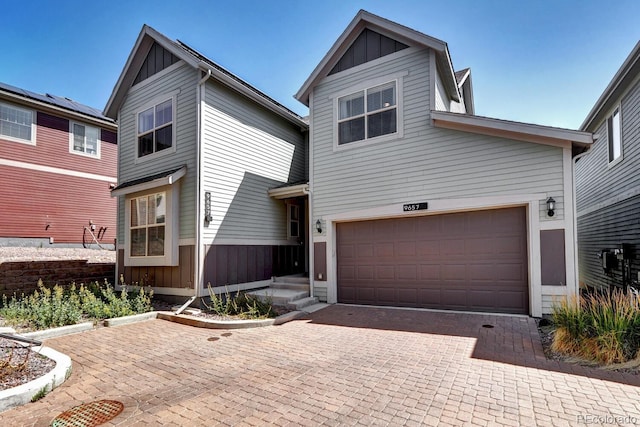 view of front of property featuring decorative driveway, board and batten siding, and an attached garage