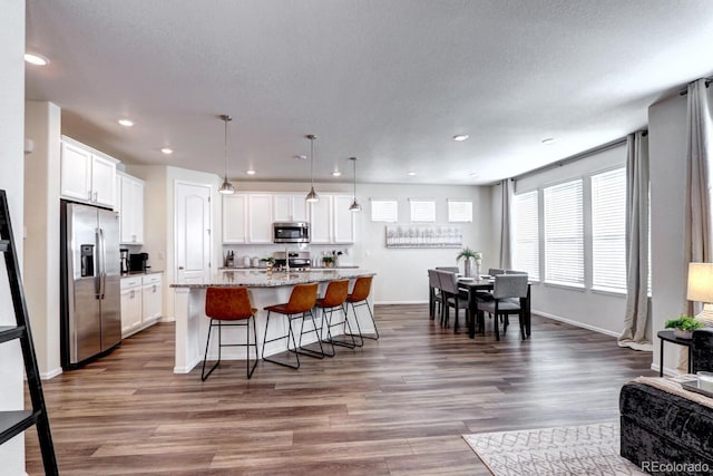 kitchen with appliances with stainless steel finishes, dark wood-type flooring, and white cabinetry