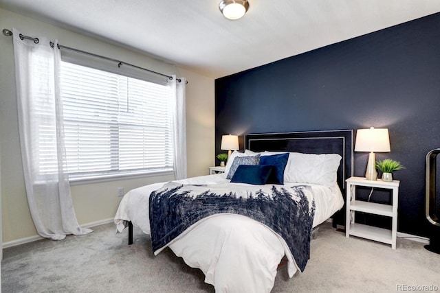 carpeted bedroom featuring multiple windows and baseboards