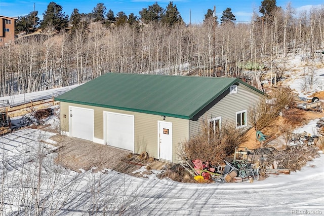 snow covered structure with a garage