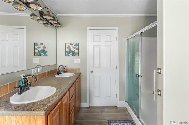 bathroom with vanity, wood-type flooring, ornamental molding, and walk in shower