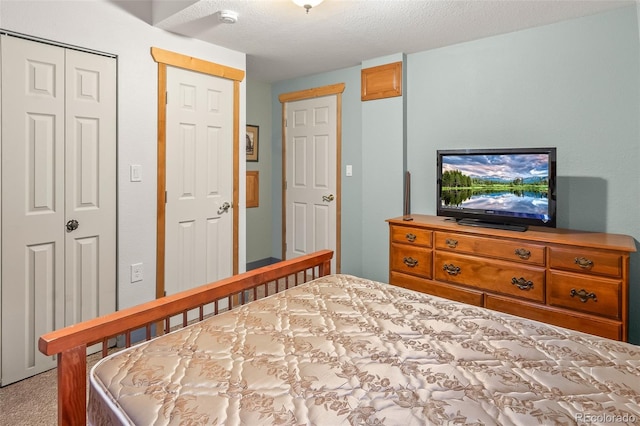 bedroom featuring light carpet and a textured ceiling