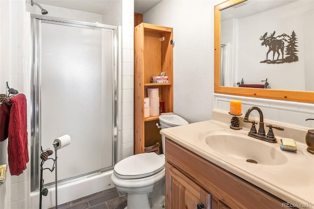 bathroom featuring vanity, toilet, and a shower with door