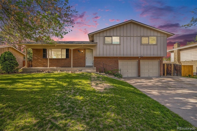 9345 W Iowa Pl, Lakewood, CO 80232 - split level home featuring board and batten siding, brick siding, a garage, and driveway