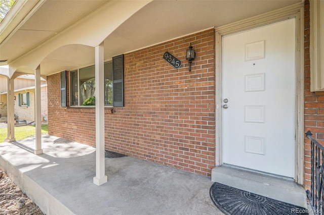 9345 W Iowa Pl, Lakewood, CO 80232 - entrance to property with a porch and brick siding