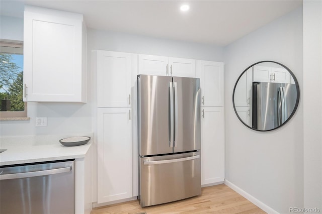 9345 W Iowa Pl, Lakewood, CO 80232 - kitchen with appliances with stainless steel finishes, white cabinetry, light wood-type flooring, light countertops, and recessed lighting