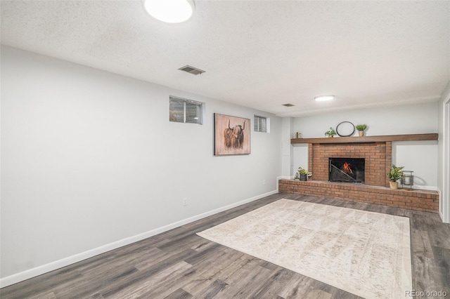 9345 W Iowa Pl, Lakewood, CO 80232 - living area featuring wood finished floors, baseboards, a fireplace, and a textured ceiling