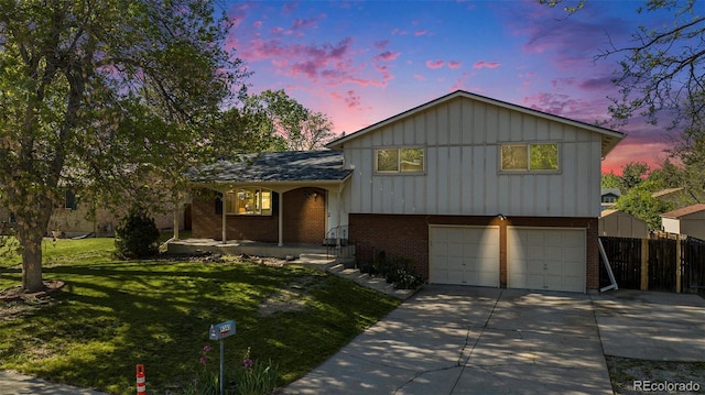 9345 W Iowa Pl, Lakewood, CO 80232 - tri-level home with brick siding, an attached garage, board and batten siding, covered porch, and concrete driveway