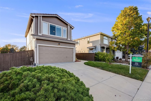 view of property featuring a front lawn and a garage