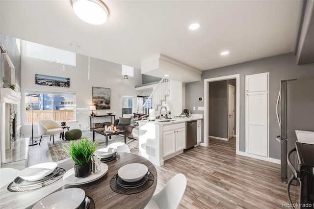 dining room featuring sink, light hardwood / wood-style flooring, and a high end fireplace