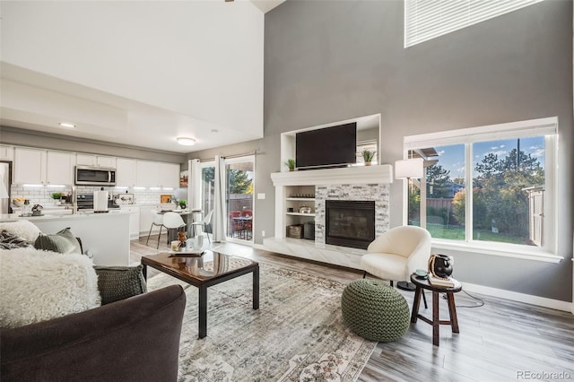 living room with light hardwood / wood-style floors and a high ceiling