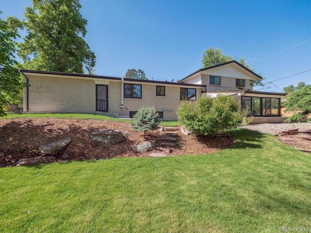11569 W 27th Ave, Lakewood, CO 80215 - back of house with brick siding, a yard, and a sunroom
