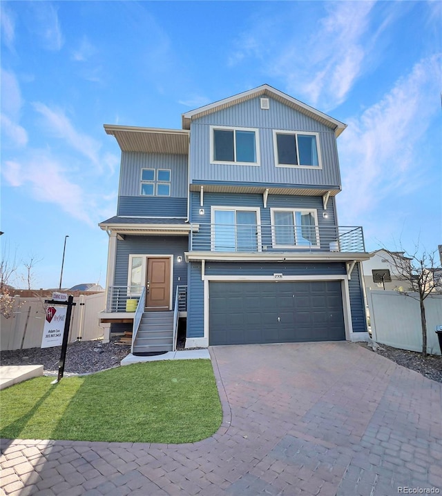 view of front of house with a garage, a front yard, decorative driveway, and fence