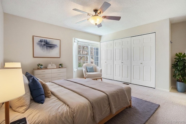 bedroom with carpet flooring, a ceiling fan, a closet, a textured ceiling, and baseboards
