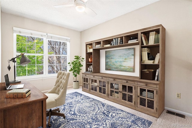 office area with ceiling fan, carpet flooring, baseboards, and a textured ceiling