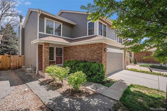traditional home featuring brick siding, fence, an attached garage, driveway, and a chimney